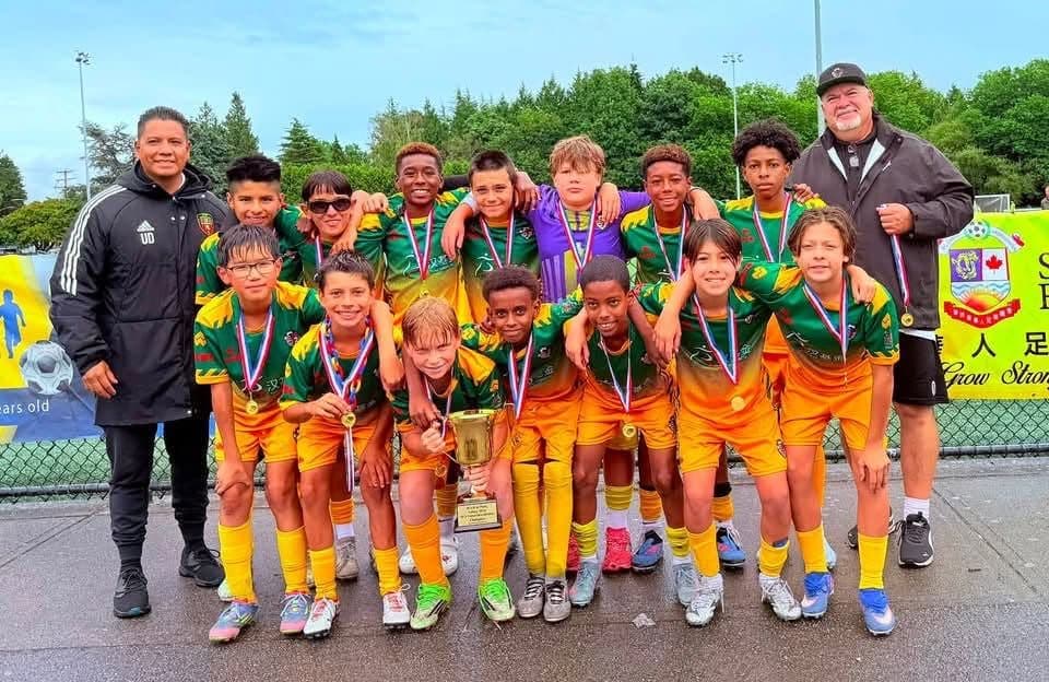 ACBC players in the green and gold kit with medals and a tournament trophy